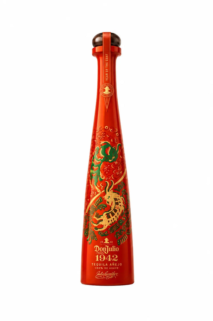 Tequila anejo bottle with red glass and ornate green-gold goat label