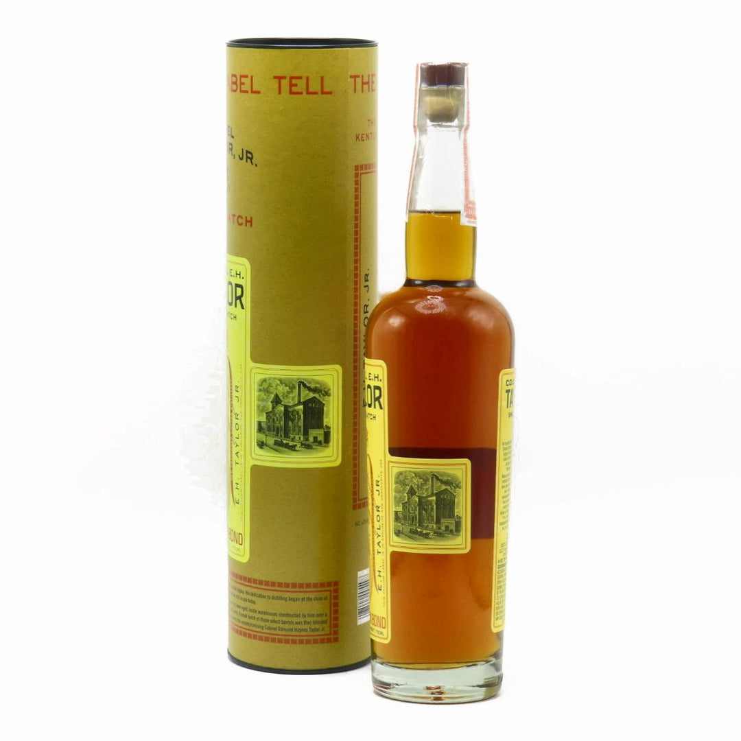 Small-batch bourbon whiskey bottle with label and carton, amber liquid in clear glass